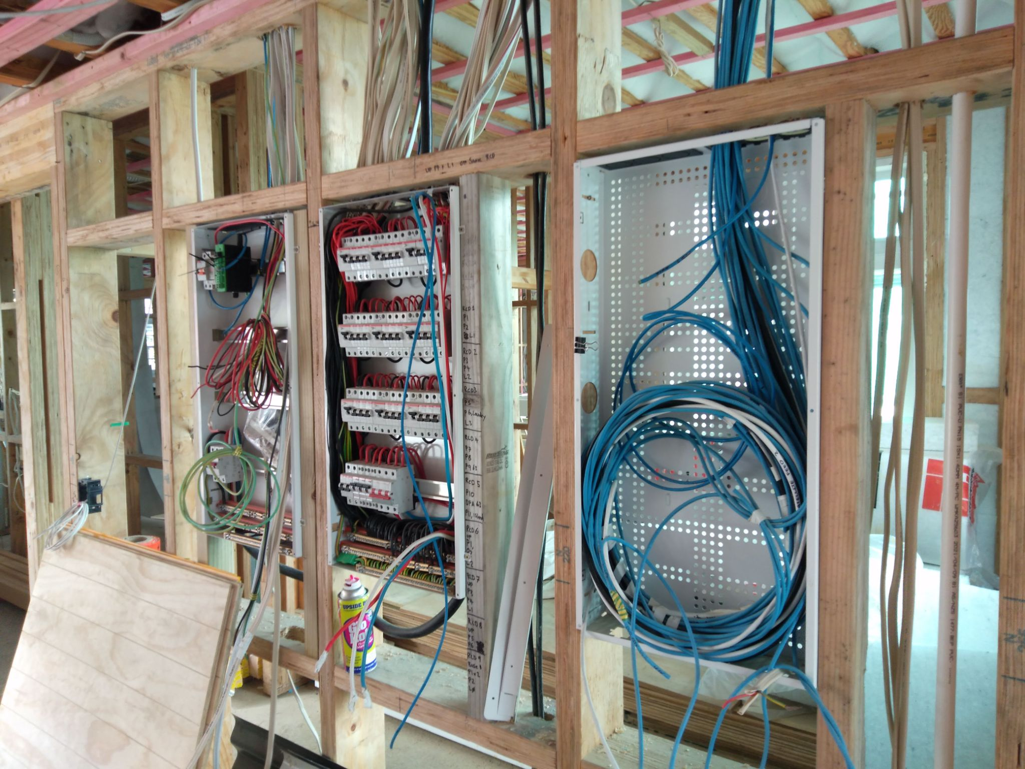 New-build wiring — labelled switchboard and structured data cabinet in framing