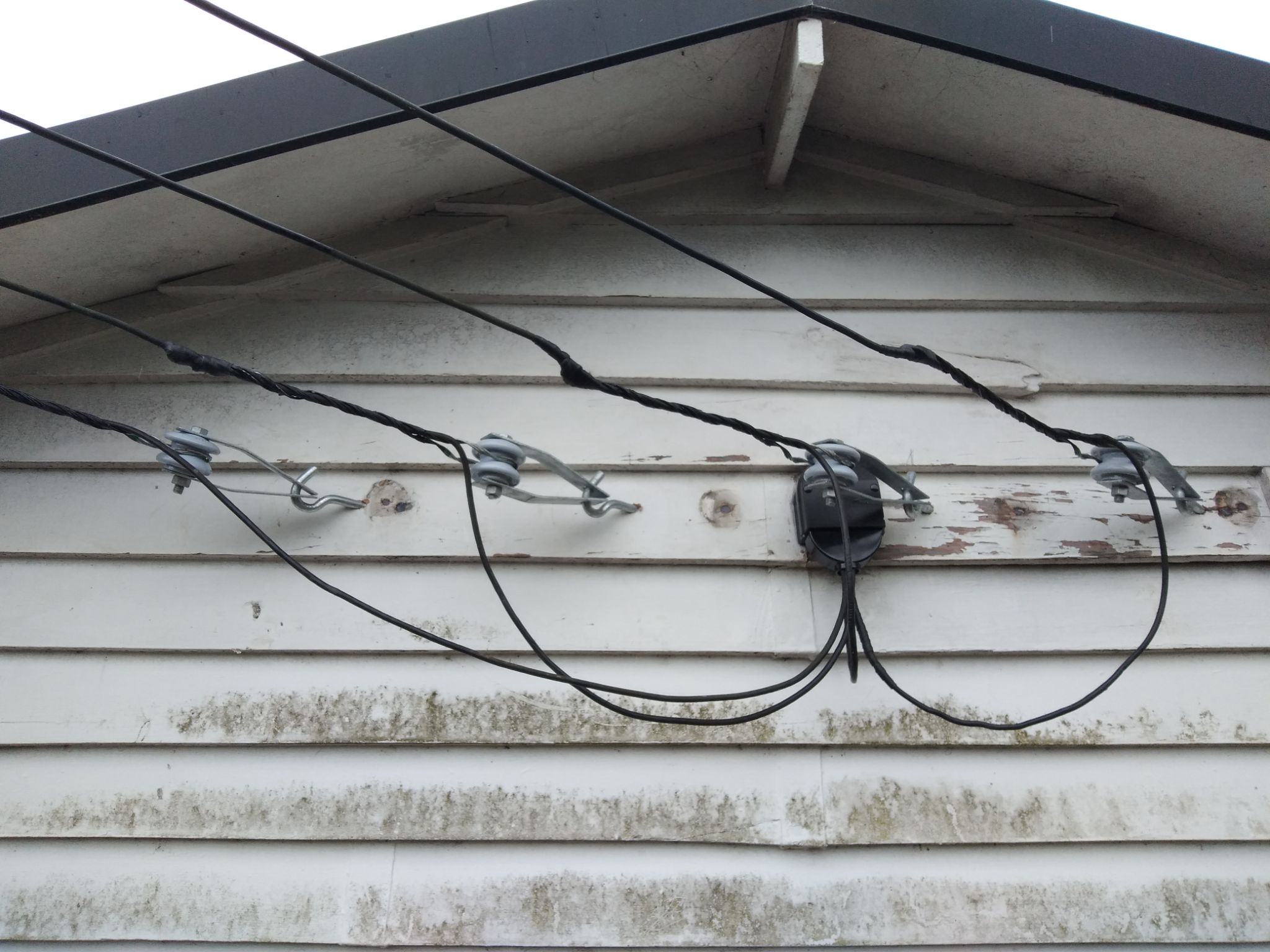 Overhead mains service entry to a weatherboard home