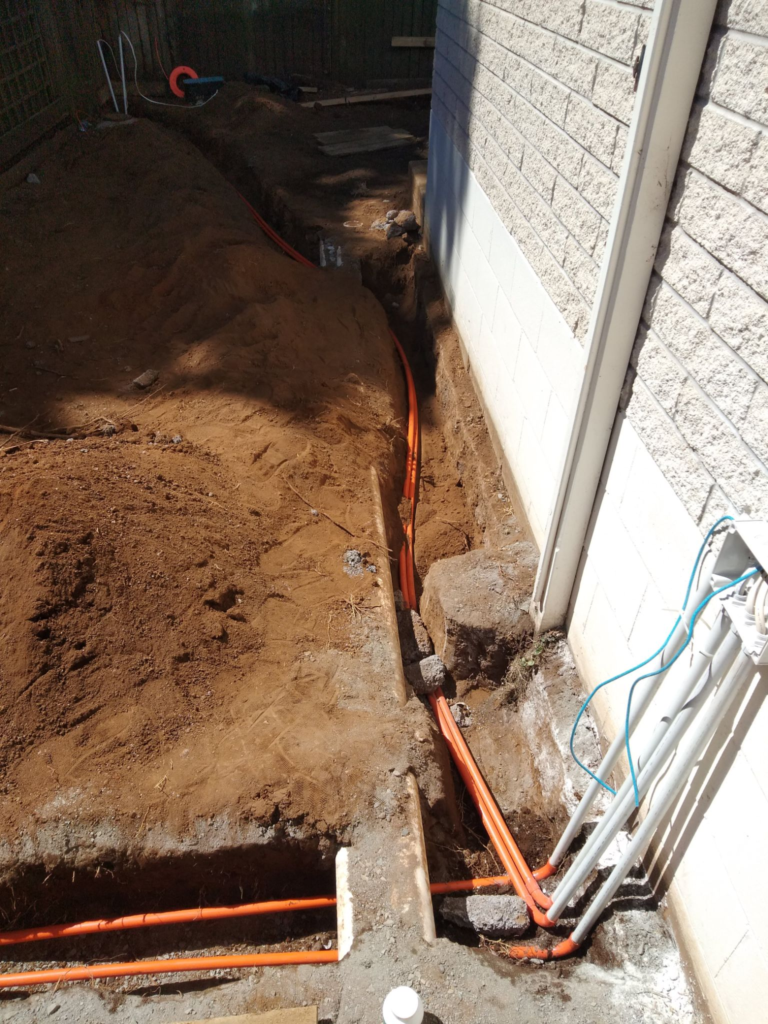 Trenched orange conduit running power and data to outbuilding