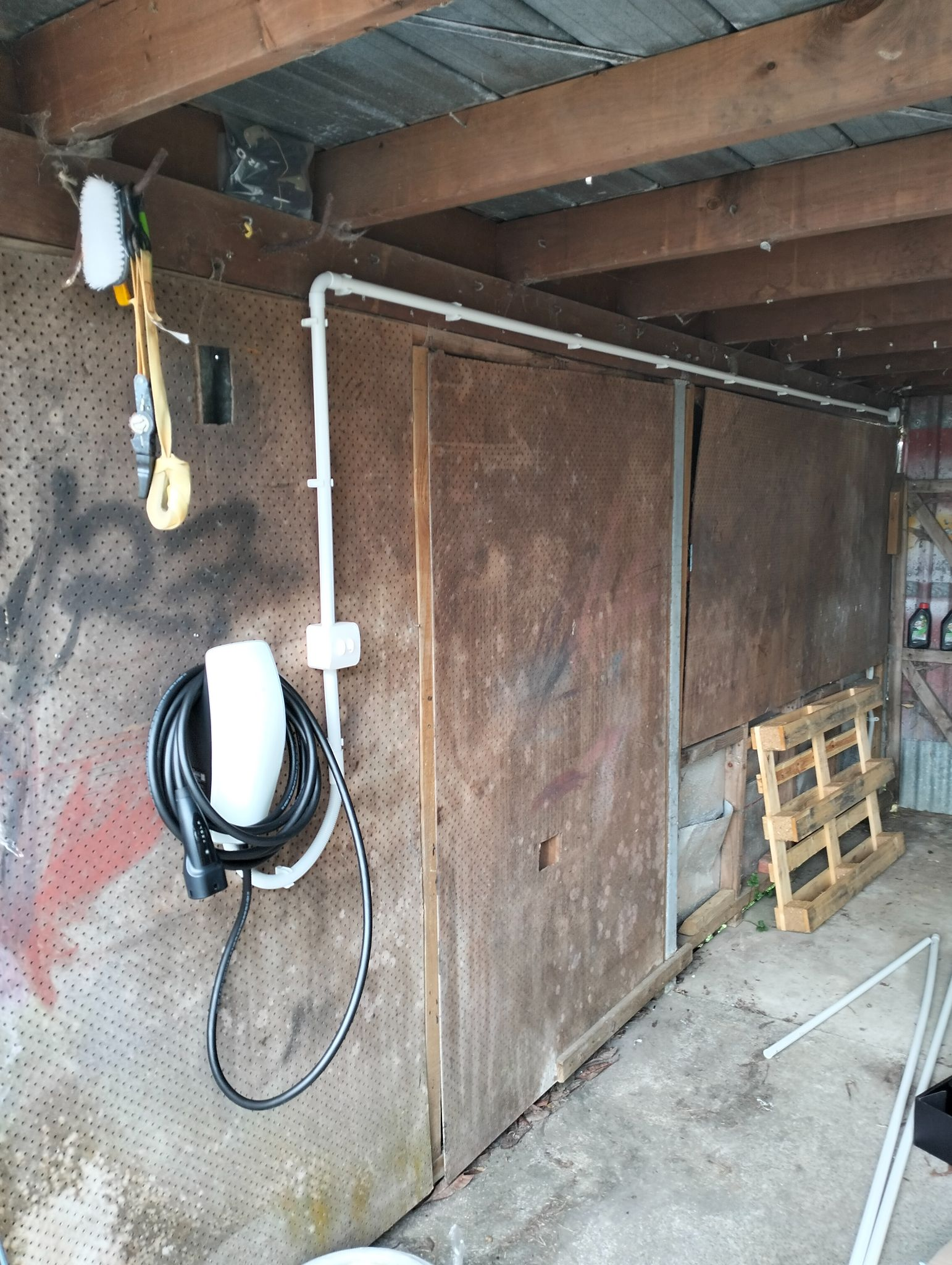 Wall-mounted EV charger in a backyard shed